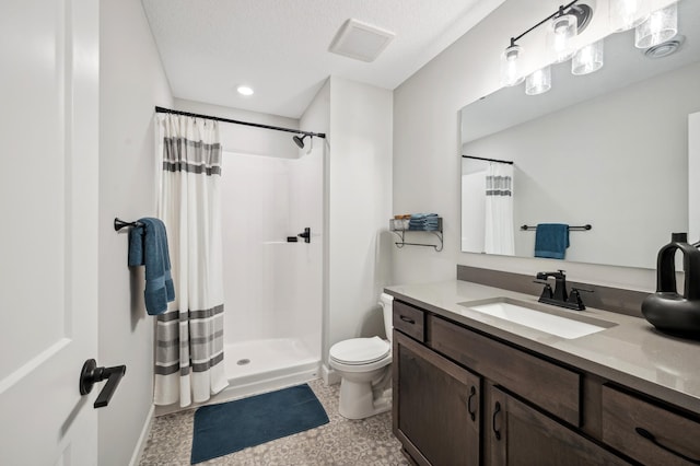 bathroom with curtained shower, vanity, a textured ceiling, and toilet