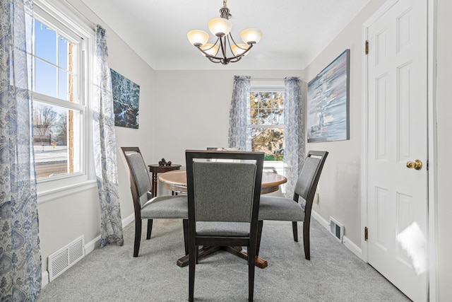 dining area with baseboards, visible vents, a chandelier, and light carpet