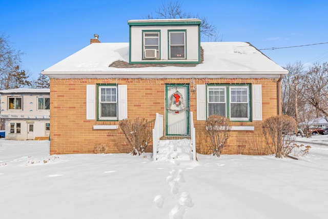 bungalow featuring brick siding and a chimney