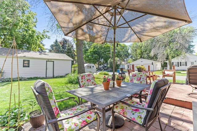 view of patio featuring outdoor dining space, a wooden deck, and an outdoor structure