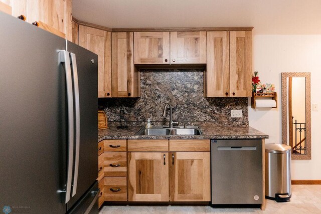 kitchen with dishwasher, a sink, backsplash, and freestanding refrigerator