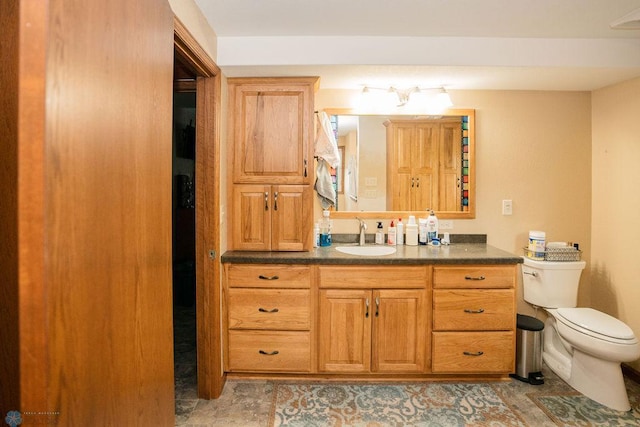 bathroom featuring tile floors, vanity with extensive cabinet space, and toilet