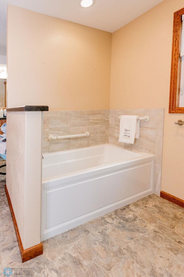 full bathroom featuring baseboards and a garden tub