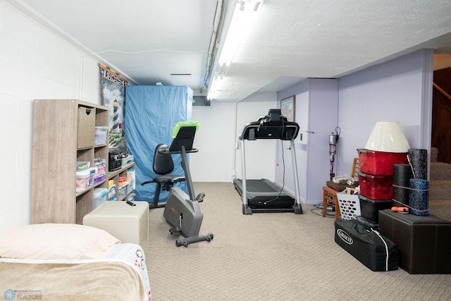 exercise room featuring carpet floors and a textured ceiling