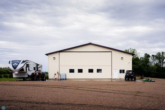 view of home's exterior with a garage, an outdoor structure, and central AC unit