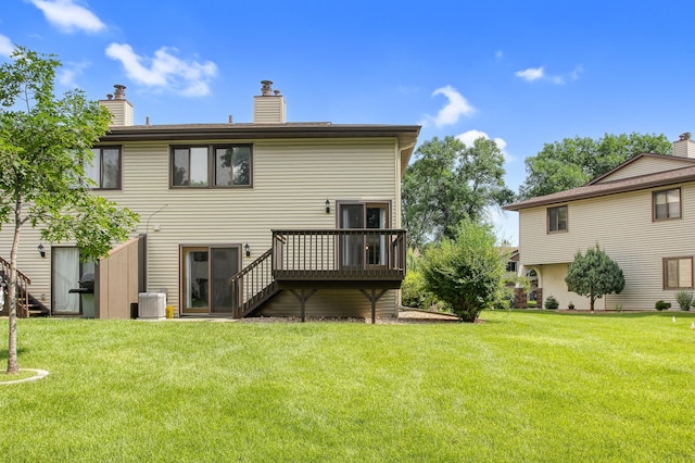 rear view of property featuring a lawn, a wooden deck, and central air condition unit