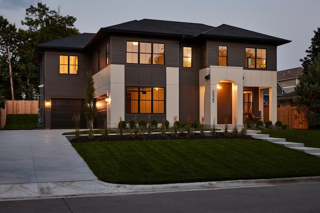 view of front of home with a garage and a lawn