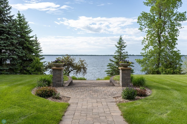 view of home's community with a water view and a yard