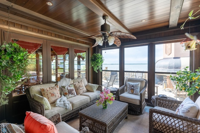 sunroom / solarium featuring beam ceiling, wood ceiling, ceiling fan, and a water view