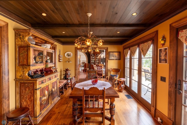 dining room with an inviting chandelier, ornamental molding, beam ceiling, wood ceiling, and wood-type flooring