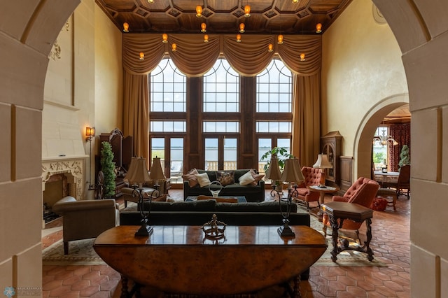 living room with a high ceiling, tile floors, and wooden ceiling