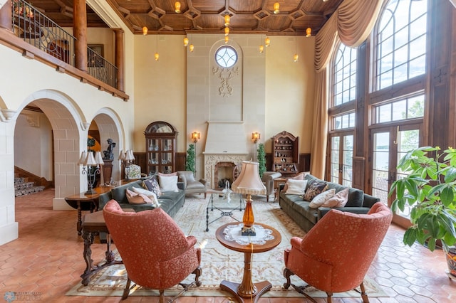 living room with a high ceiling, wood ceiling, and light tile floors