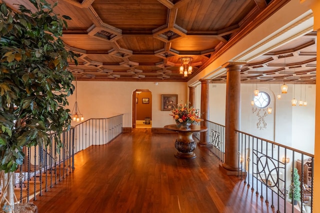 corridor featuring ornamental molding, hardwood / wood-style floors, a notable chandelier, coffered ceiling, and wood ceiling