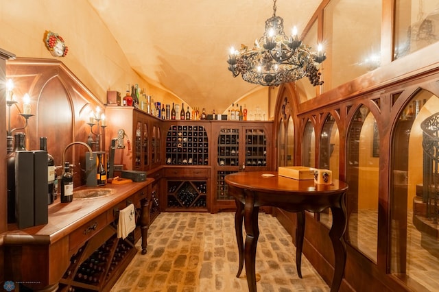 wine cellar featuring high vaulted ceiling and an inviting chandelier