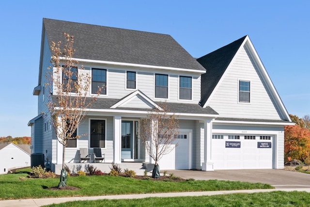 view of front facade featuring a front yard, a garage, cooling unit, and a porch