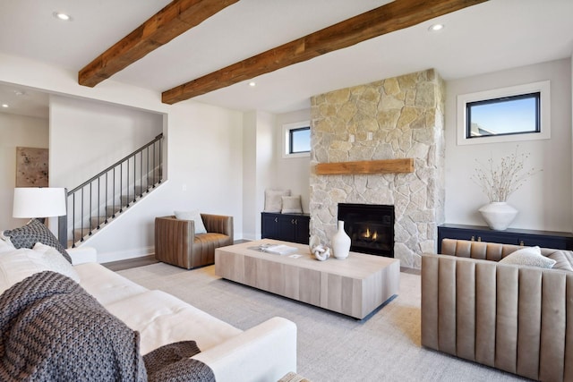 living room with a stone fireplace, beam ceiling, and light carpet