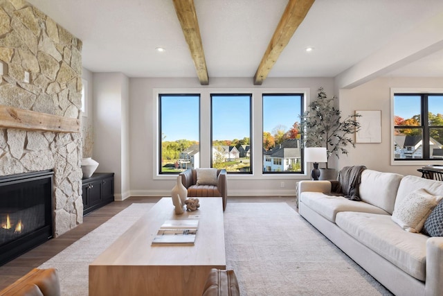 living room with beam ceiling, hardwood / wood-style floors, and a fireplace