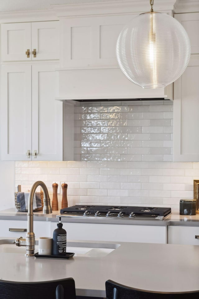 kitchen featuring white cabinetry, gas cooktop, and tasteful backsplash