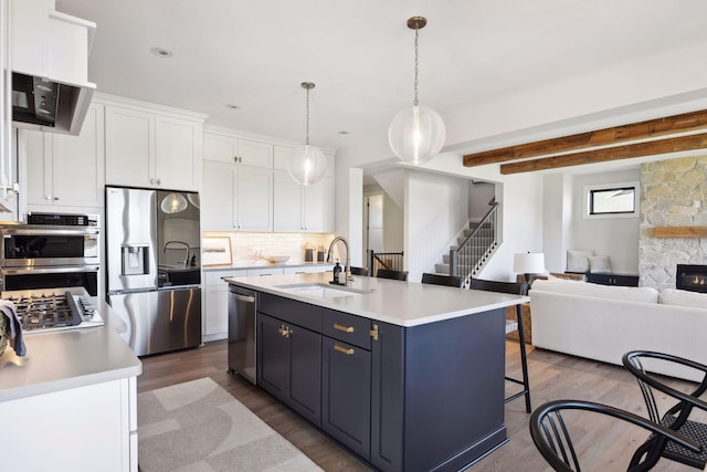 kitchen featuring white cabinets, a kitchen island with sink, dark hardwood / wood-style floors, sink, and stainless steel appliances