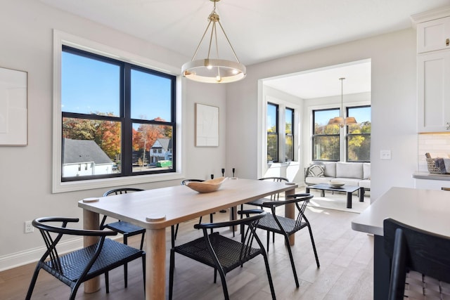 dining space featuring light hardwood / wood-style floors and a chandelier