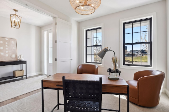 dining space with a healthy amount of sunlight, an inviting chandelier, and light wood-type flooring