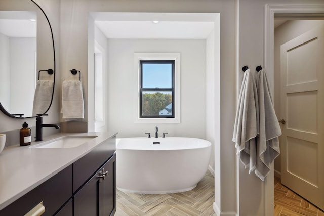 bathroom with vanity, a tub to relax in, and parquet floors