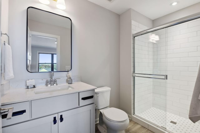 bathroom featuring vanity, toilet, and an enclosed shower