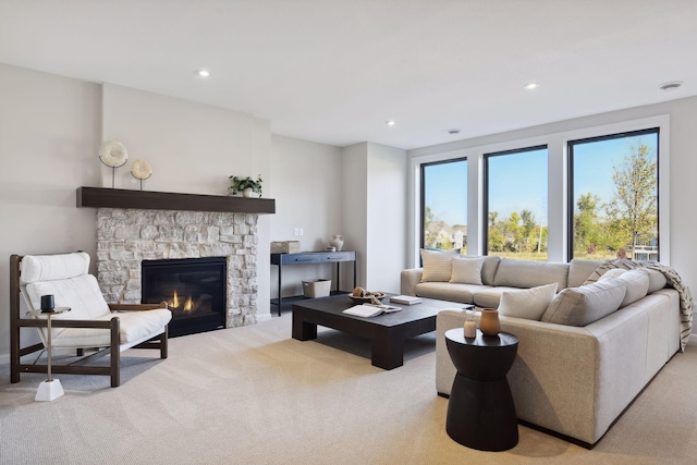 living room featuring a stone fireplace and light colored carpet