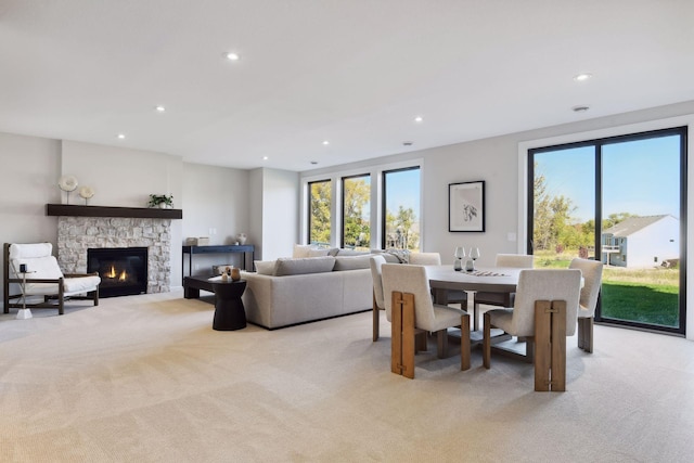 dining area with light carpet and a fireplace