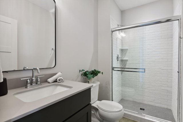 bathroom with vanity, a shower with shower door, toilet, and tile patterned floors