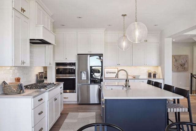 kitchen with a center island with sink, white cabinets, stainless steel appliances, and sink