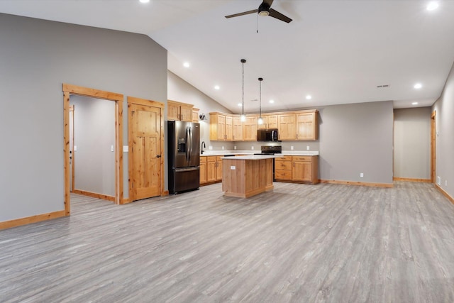 kitchen with ceiling fan, light wood-type flooring, decorative light fixtures, a kitchen island, and stainless steel appliances