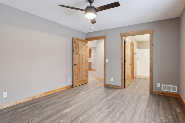 unfurnished bedroom featuring connected bathroom, ceiling fan, and light hardwood / wood-style flooring