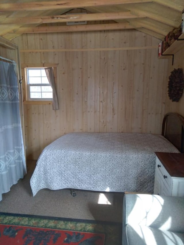 bedroom with wooden walls and vaulted ceiling