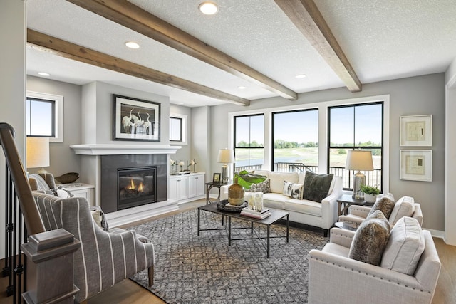 living room with beamed ceiling, a textured ceiling, and dark hardwood / wood-style flooring