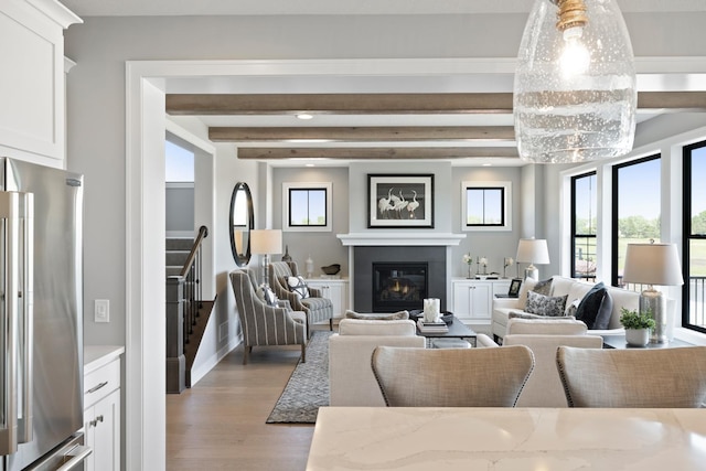 living room featuring beamed ceiling and light hardwood / wood-style flooring