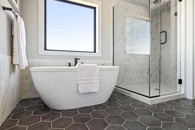 bathroom featuring tile patterned flooring, tile walls, and plenty of natural light