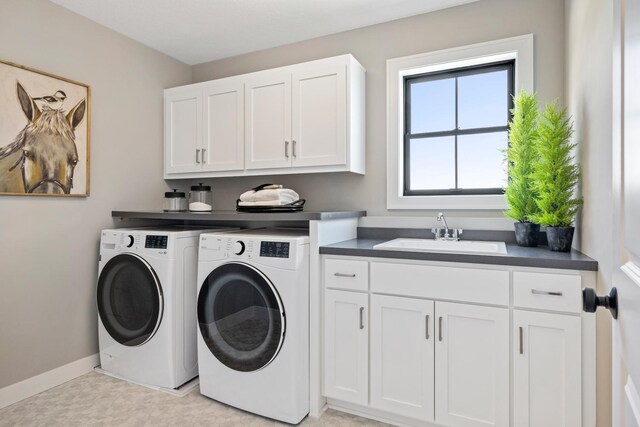 laundry room featuring sink, washer and dryer, and cabinets