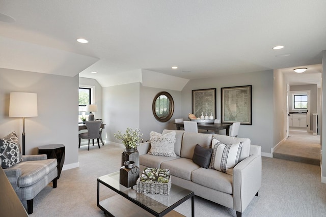 carpeted living room with lofted ceiling and a wealth of natural light