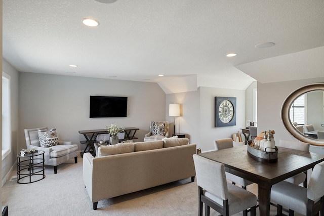 living room featuring light carpet, lofted ceiling, and a textured ceiling