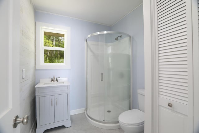 full bath featuring toilet, vanity, baseboards, a closet, and a stall shower