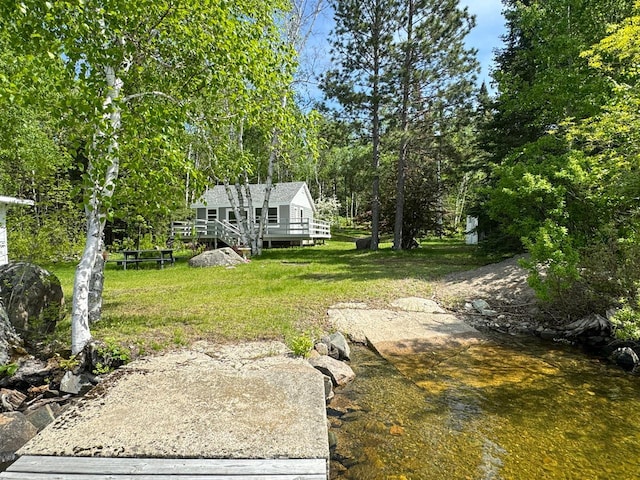 view of yard with a deck with water view