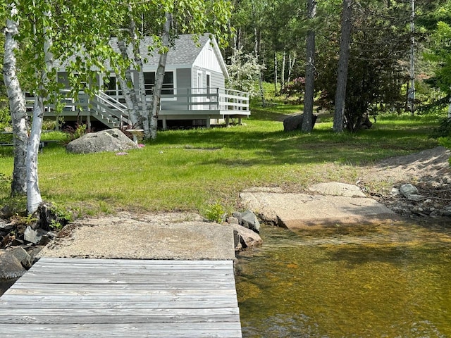 view of dock with a lawn and a deck with water view