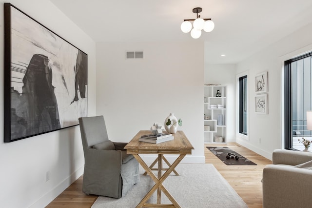 office space with hardwood / wood-style flooring and a chandelier