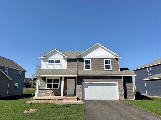 view of front of property featuring a front yard, a porch, and a garage