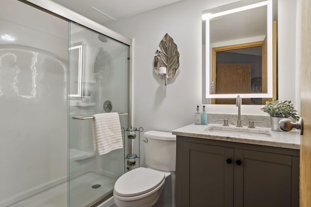 bathroom featuring toilet, vanity, and walk in shower