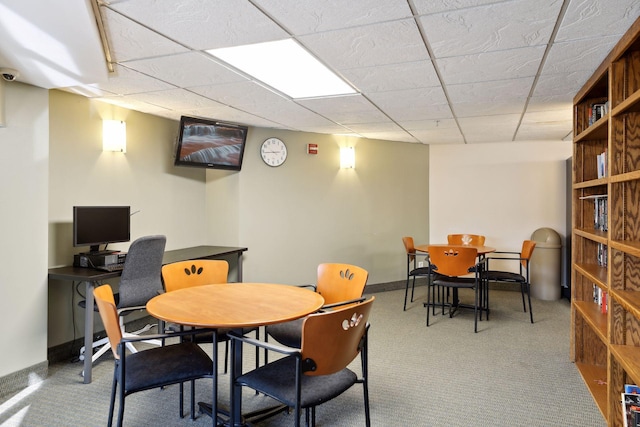 carpeted dining space with a paneled ceiling