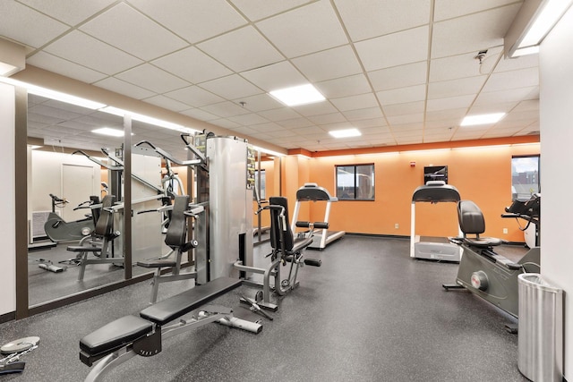 exercise room featuring a drop ceiling and a healthy amount of sunlight