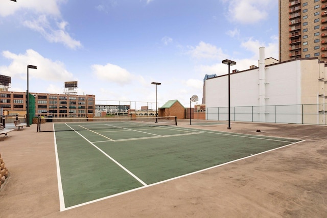 view of tennis court with basketball hoop