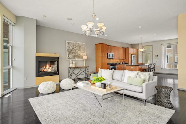 living room featuring a chandelier and dark wood-type flooring